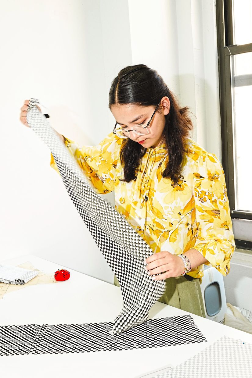 A student works with a piece of fabric at the centre.