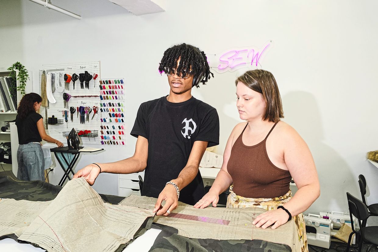 Nathaniel McDonald (left) works on a pair of camouflage denim jeans at the centre.