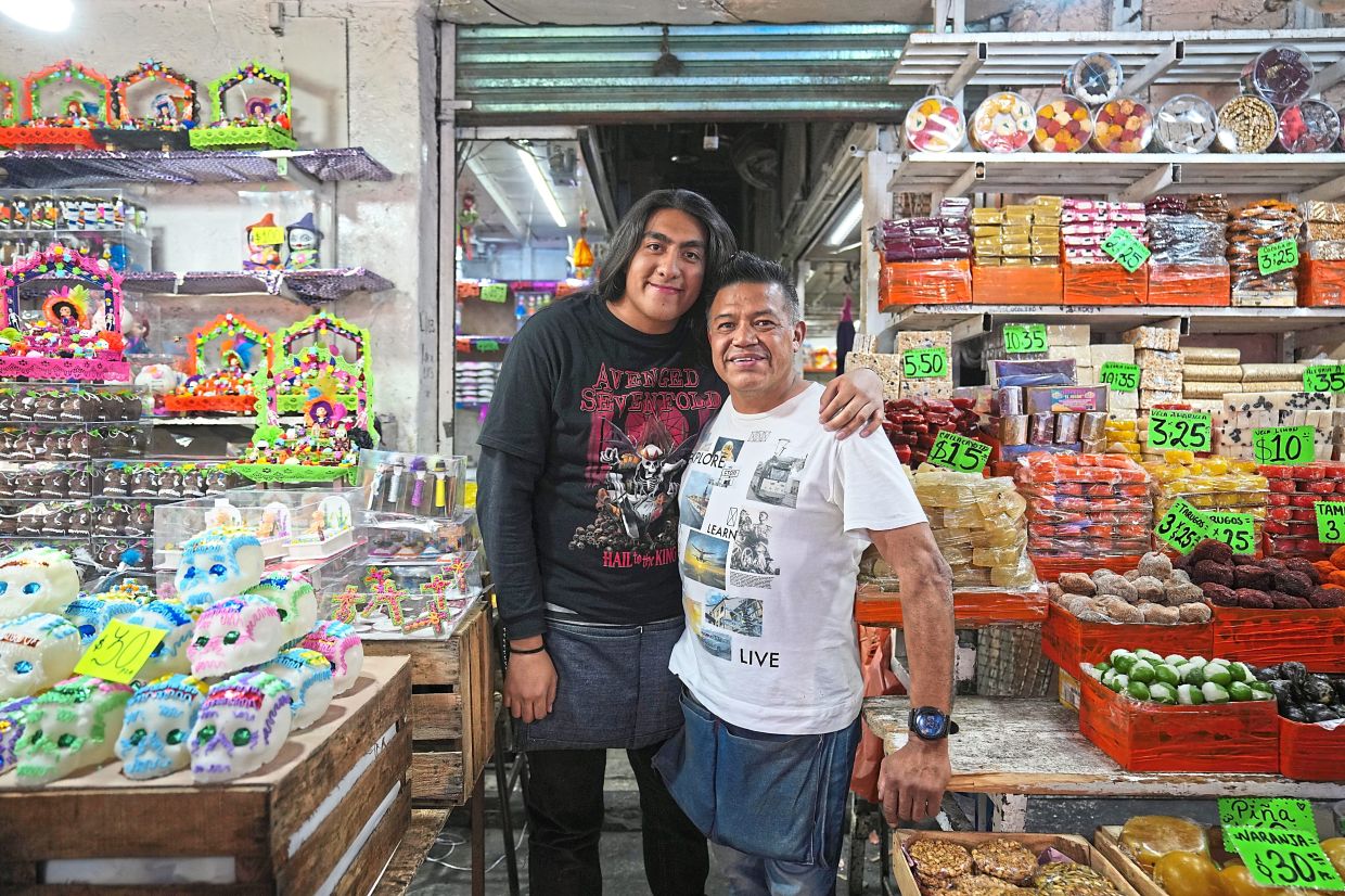 Chavarria (right) and his son Emmanuel at their stand where they sell calaveritas.