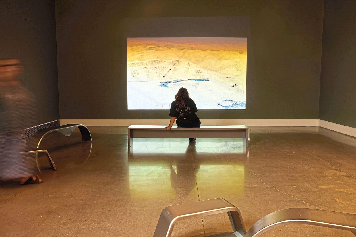 A visitor views a work on display in the exhibition Fia Backstrom: The Great Society, at the Queens Museum in New York. 
