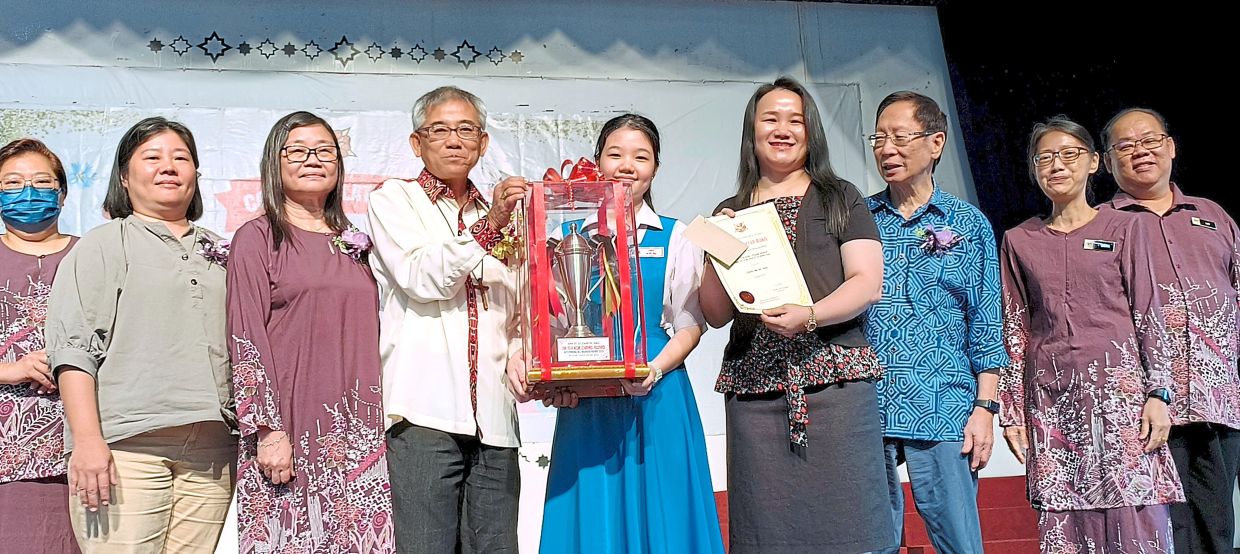 Hii (fourth from left) presenting the outstanding all-rounder award to Cindy. With them is Chee (third from left).