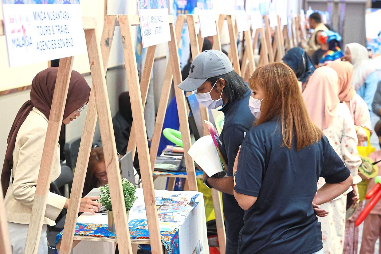 讨价还价：游客们在 11 月 7 日至 9 日在新山 Paradigm Mall 会议中心举办的 Star Karnival Cuti-Cuti Malaysia 寻找最佳旅游优惠。 — THOMAS YONG/The Star