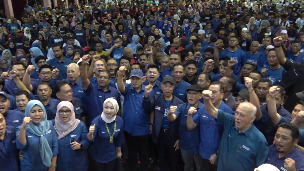 Perikatan Nasional chairman Tan Sri Muhyiddin Yassin (centre, in cap) joins party leaders and supporters in a show of unity during the launch of Perikatan's election machinery in Sandakan.