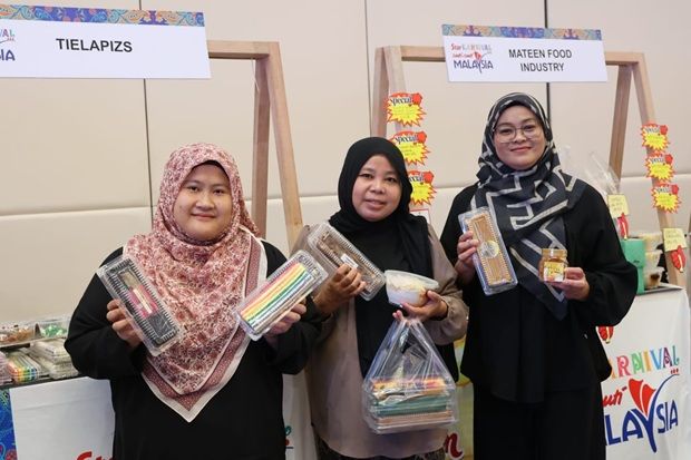 Tielapizs 和 Mateen 食品工业经营者 Hariayati Abu Samah(中)和她的团队将来自砂拉越的各种口味的 kek lapis 和其他小吃带到了新山 Paradigm Mall 会议中心的 Star Karnival Cuti-Cuti Malaysia (SKCCM)。
