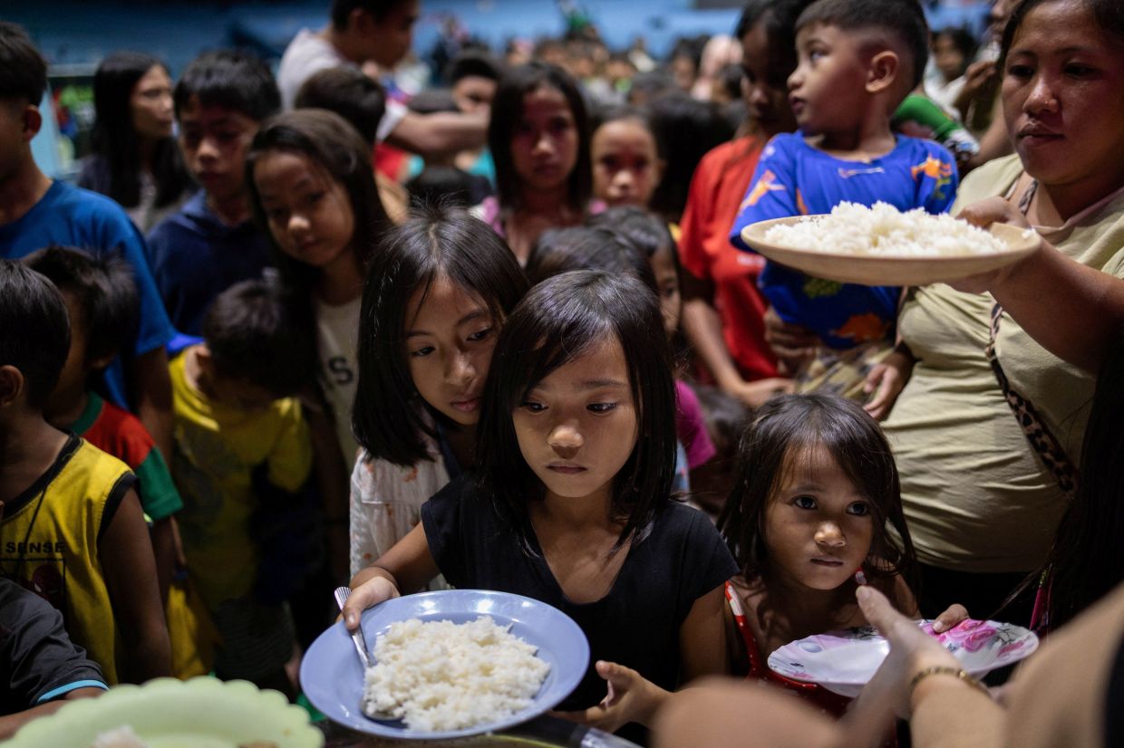 Residents who were evacuated ahead of Typhoon Fung-wong queue for food at an evacuation center in Cauayan, Isabela, Philippines, Sunday, November 9, 2025. -- Photo: REUTERS/Eloisa Lopez