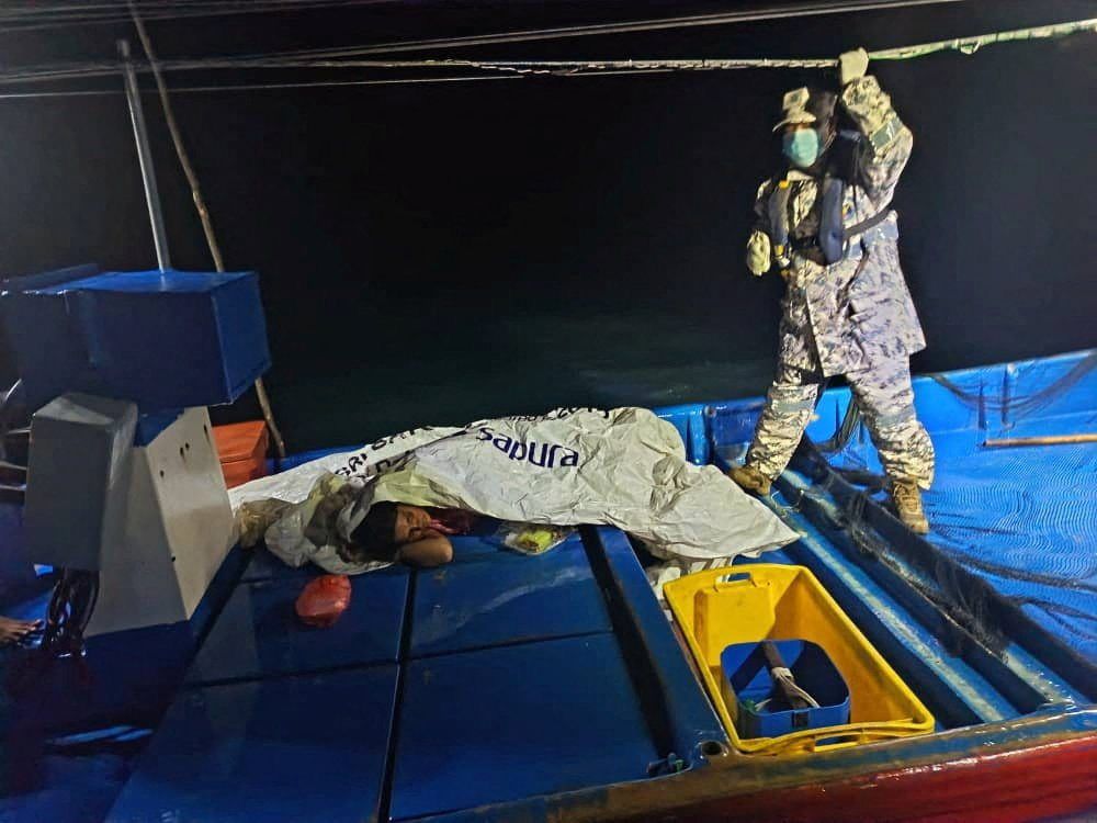 A staff member of the Malaysian Maritime Enforcement Agency checks on a survivor who was rescued by a fishing boat's crew after a boat from Buthidaung, Myanmar, sank near the Malaysia–Thailand border, close to Langkawi, Malaysia, on Sunday, November 9, 2025. -- Photo: Malaysian Maritime Enforcement Agency via Reuters