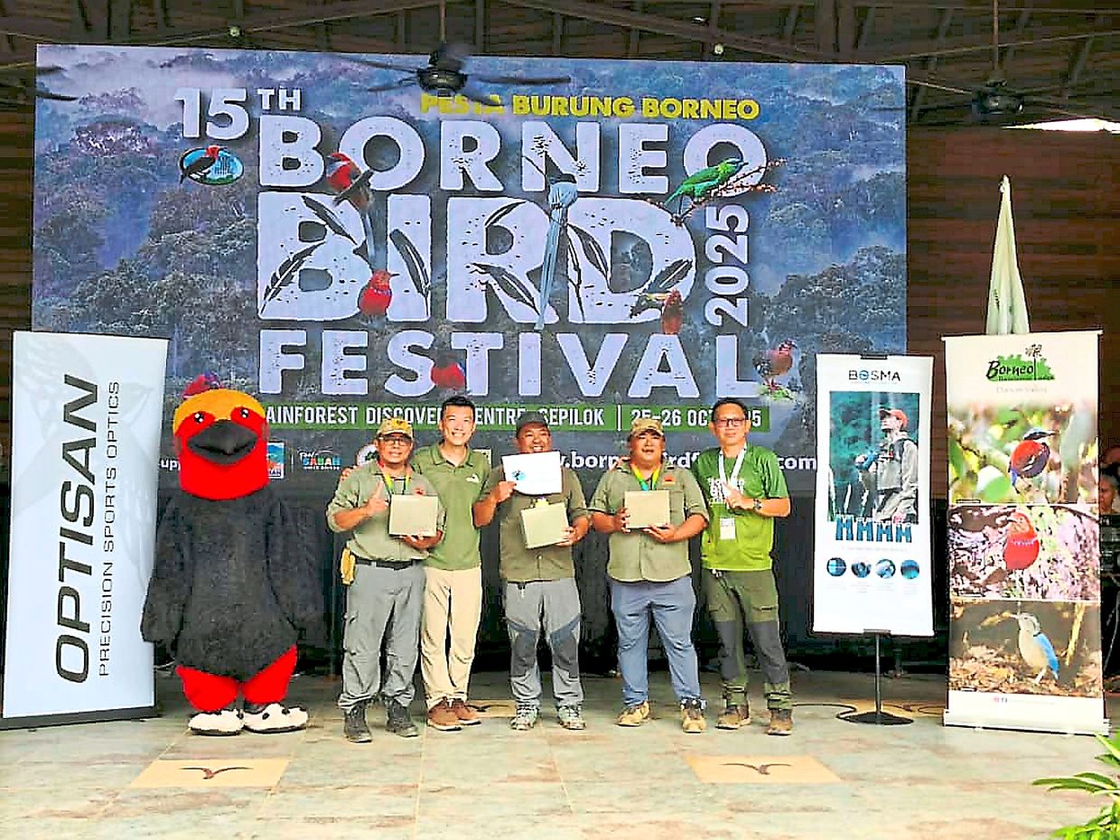 SI Tour team, winners of the Borneo Bird Race 2025, receiving their prizes on stage.