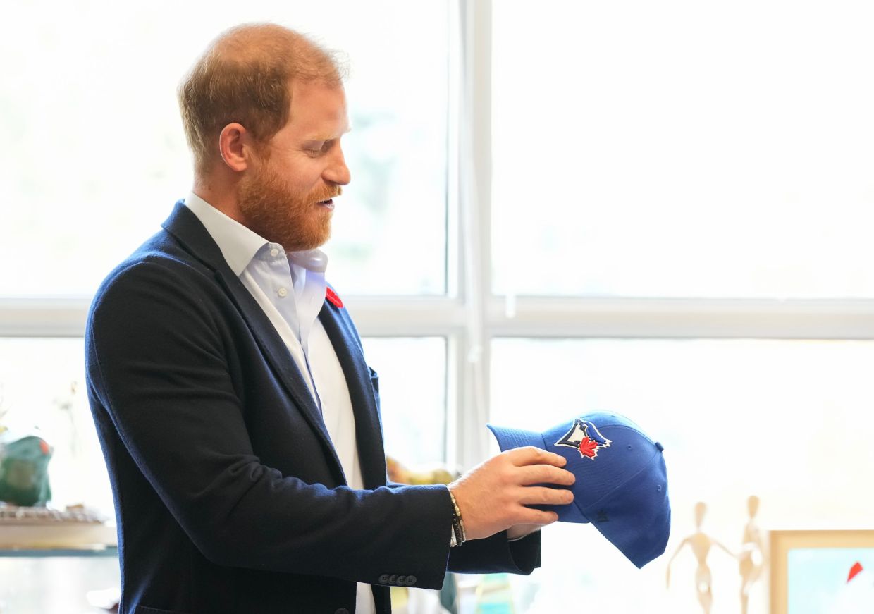 Prince Harry received a Toronto Blue Jays hat as he meets with some of Canada's oldest veterans, joining them in a creative arts program at Sunnybrook Hospital's veterans center in Toronto, Thursday, Nov. 6, 2025. Photo via AP