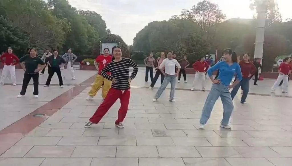 Yang taking part in a square dancing session with a group of “aunties” in a park. - Baidu