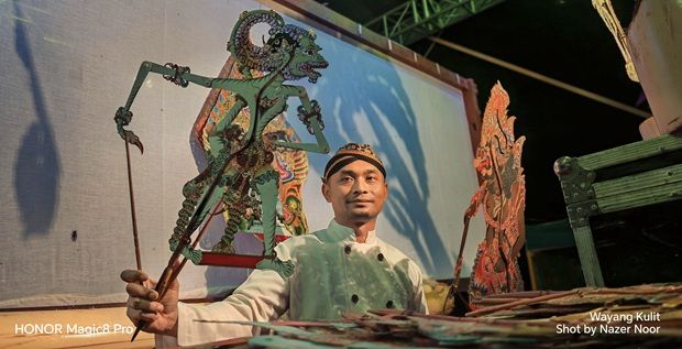 The traditional art of Malaysian Wayang Kulit, featuring a master puppeteer bringing diverse stories to life, is captured in vivid detail by the HONOR Magic8 Pro as it documents the nation's heritage for Visit Malaysia 2026.