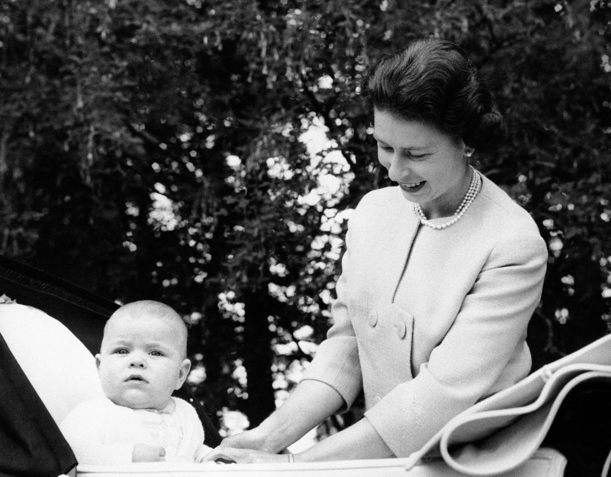 Prince Andrew sits up in his carriage as his mother, Queen Elizabeth II, smiles down at him, when the baby prince was nearing his seventh month birthday, Sept 13, 1960. Photo: AP