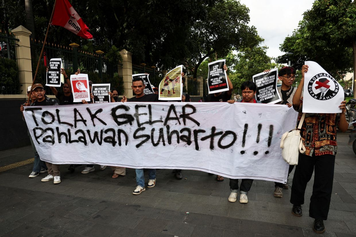 Activists carrying a banner reading - Against the Hero title of Suharto - and posters march toward the Ministry of Culture building during a protest against former Indonesian President Suharto, who was named a national hero, in Jakarta, Indonesia, Monday, November 10, 2025. -- Photo: REUTERS/Willy Kurniawan