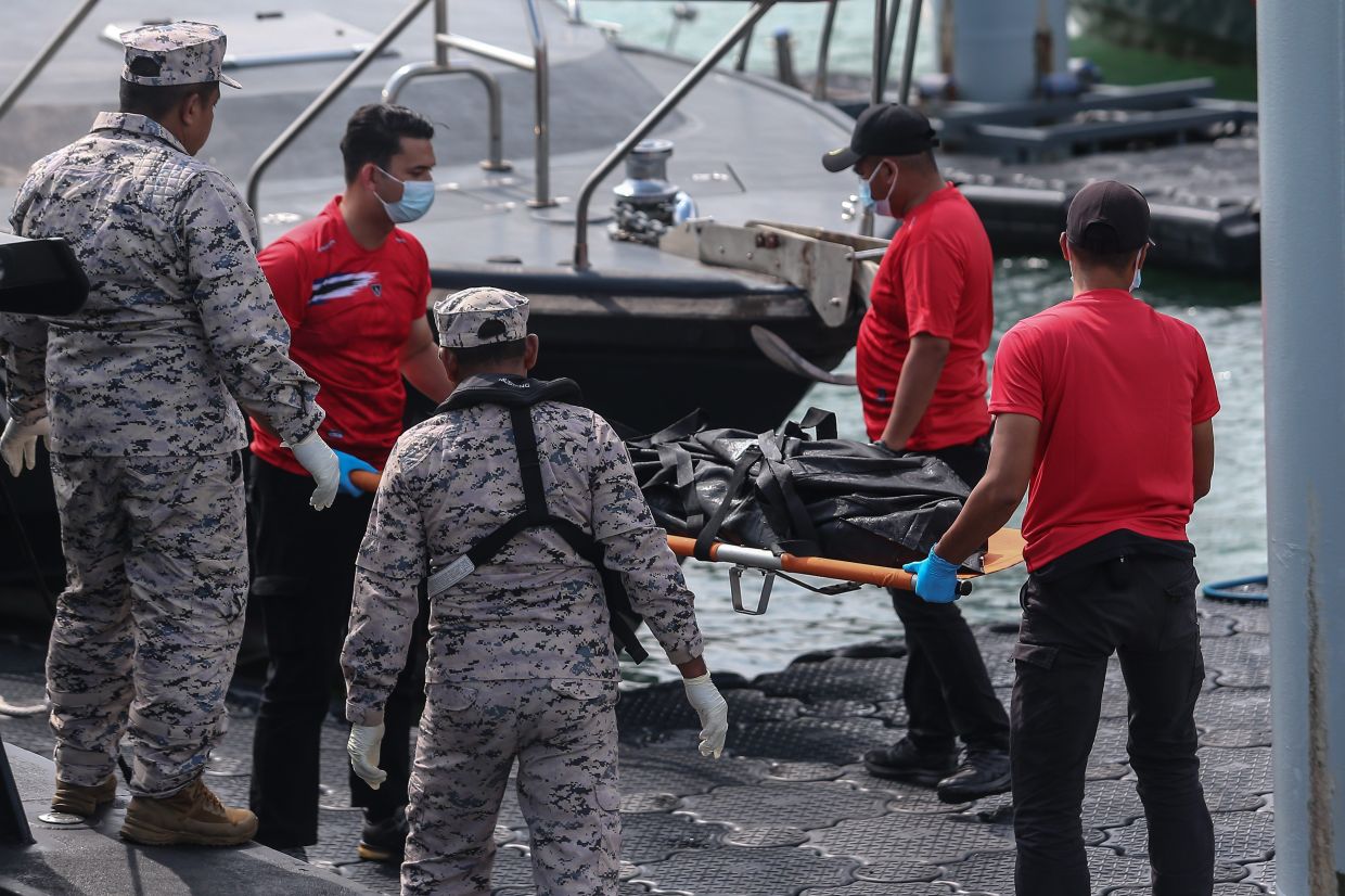 Malaysian Maritime Enforcement Agency officers wearing face masks and gloves as they prepare to carry the body of a victim after a boat carrying members of Myanmar's persecuted Rohingya community sank in waters near the Thailand-Malaysia border, in Langkawi, Malaysia, on Monday, November 10, 2025. -- Photo: Bernama
