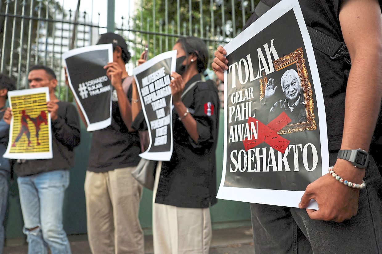 Not our hero: Activists holding posters during a protest against Suharto receiving the national hero title, outside the Ministry of Culture building in Jakarta. — Reuters