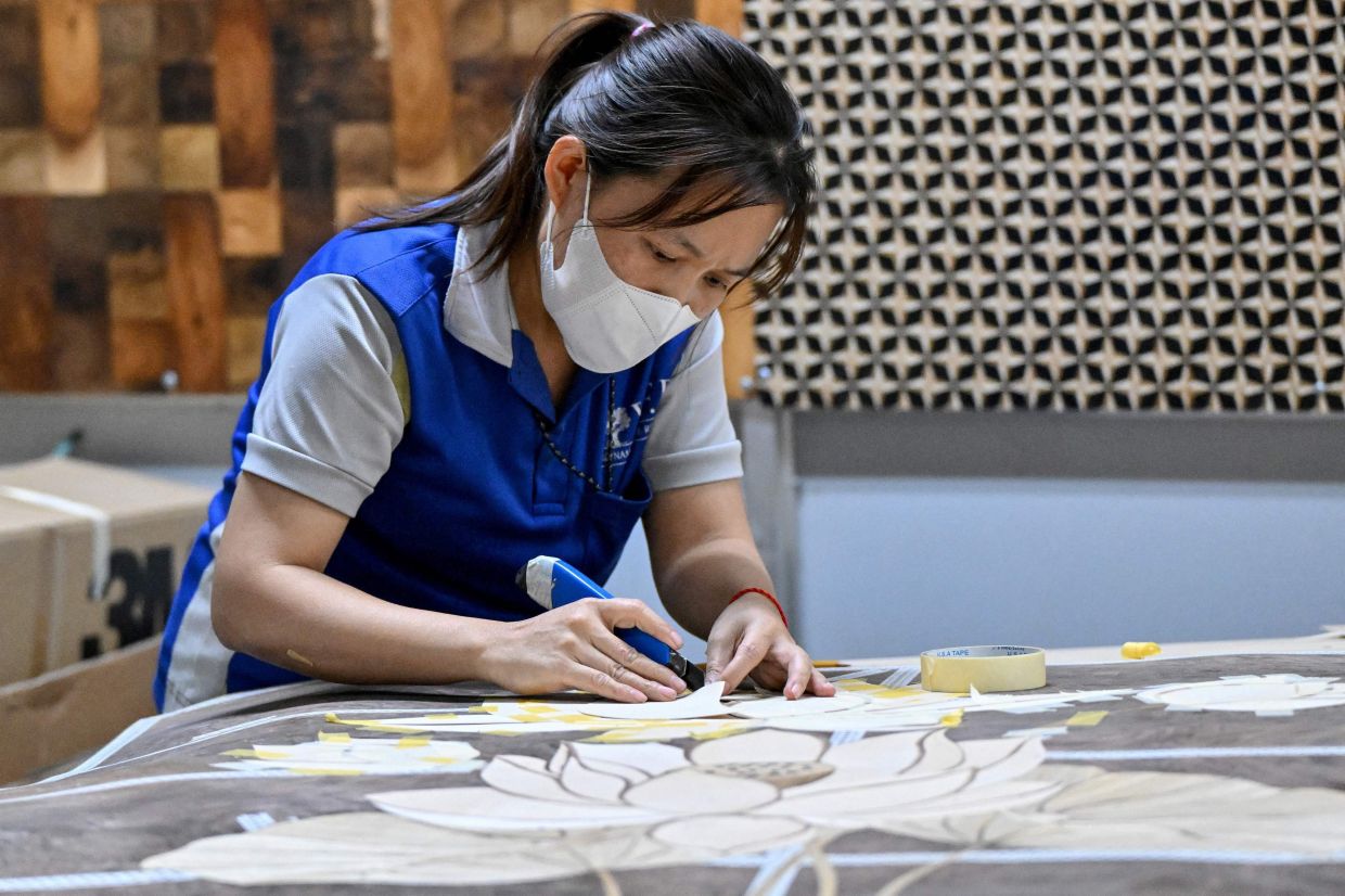 An employee working inside the Jonathan Charles Fine Furniture factory in Ho Chi Minh City. -- Photo by Nhac NGUYEN / AFP