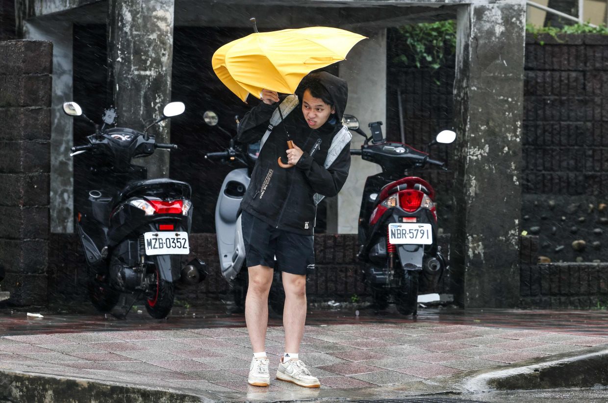 A pedestrian holds an umbrella in strong wind and rain caused by the approach of Typhoon Fung-Wong in Keelung on Tuesday, November 11, 2025. -- Photo by I-Hwa Cheng / AFP