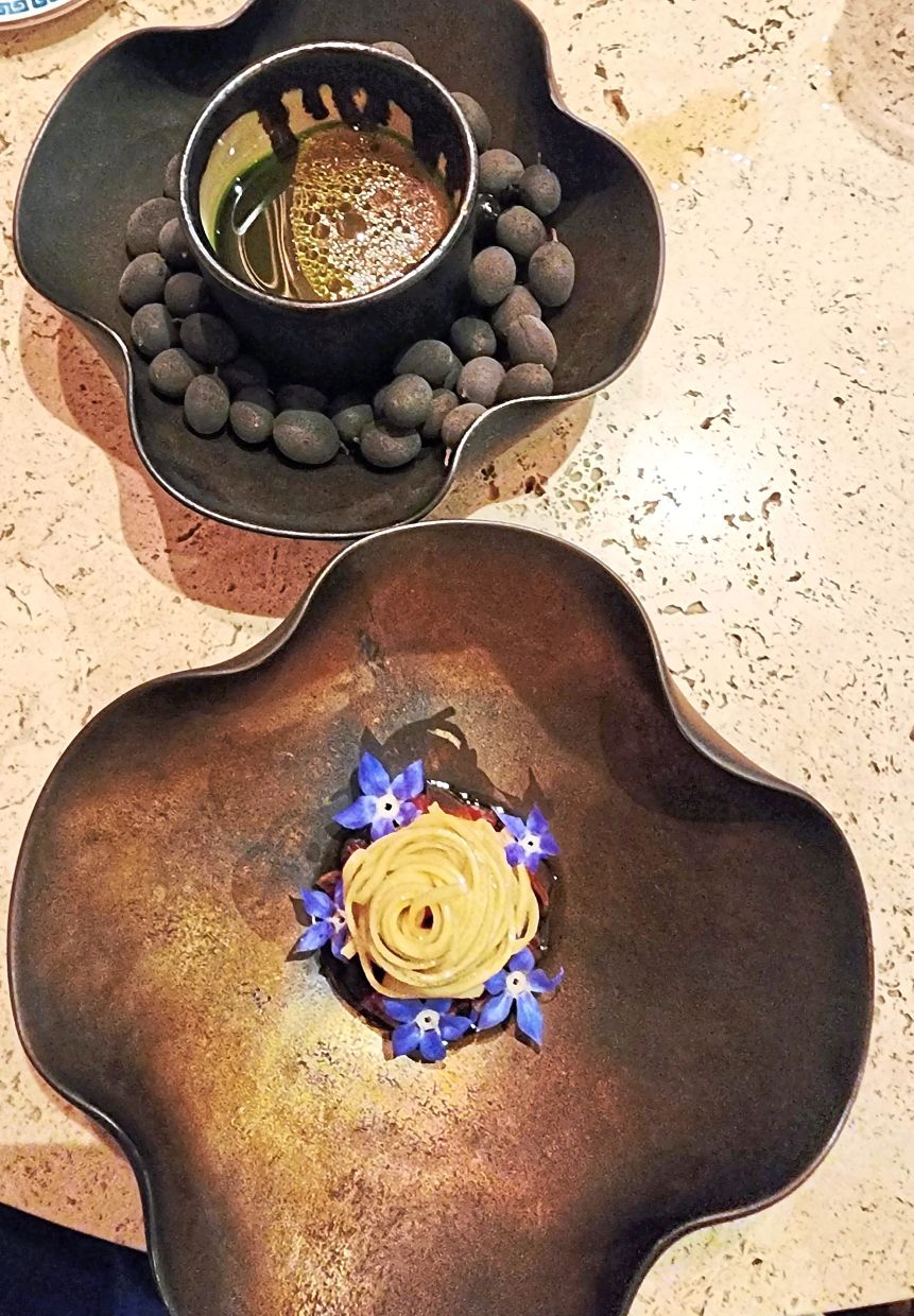 Beef bone broth and beef tartare under a blanket of noodles.