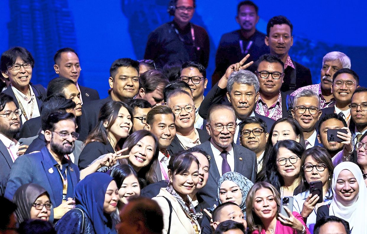 Anwar, Mohamad Hasan and Investment, Trade and Industry Minister Tengku Datuk Seri Zafrul Abdul Aziz posing for a group photo with members of the media after the event. — AZMAN GHANI/The Star