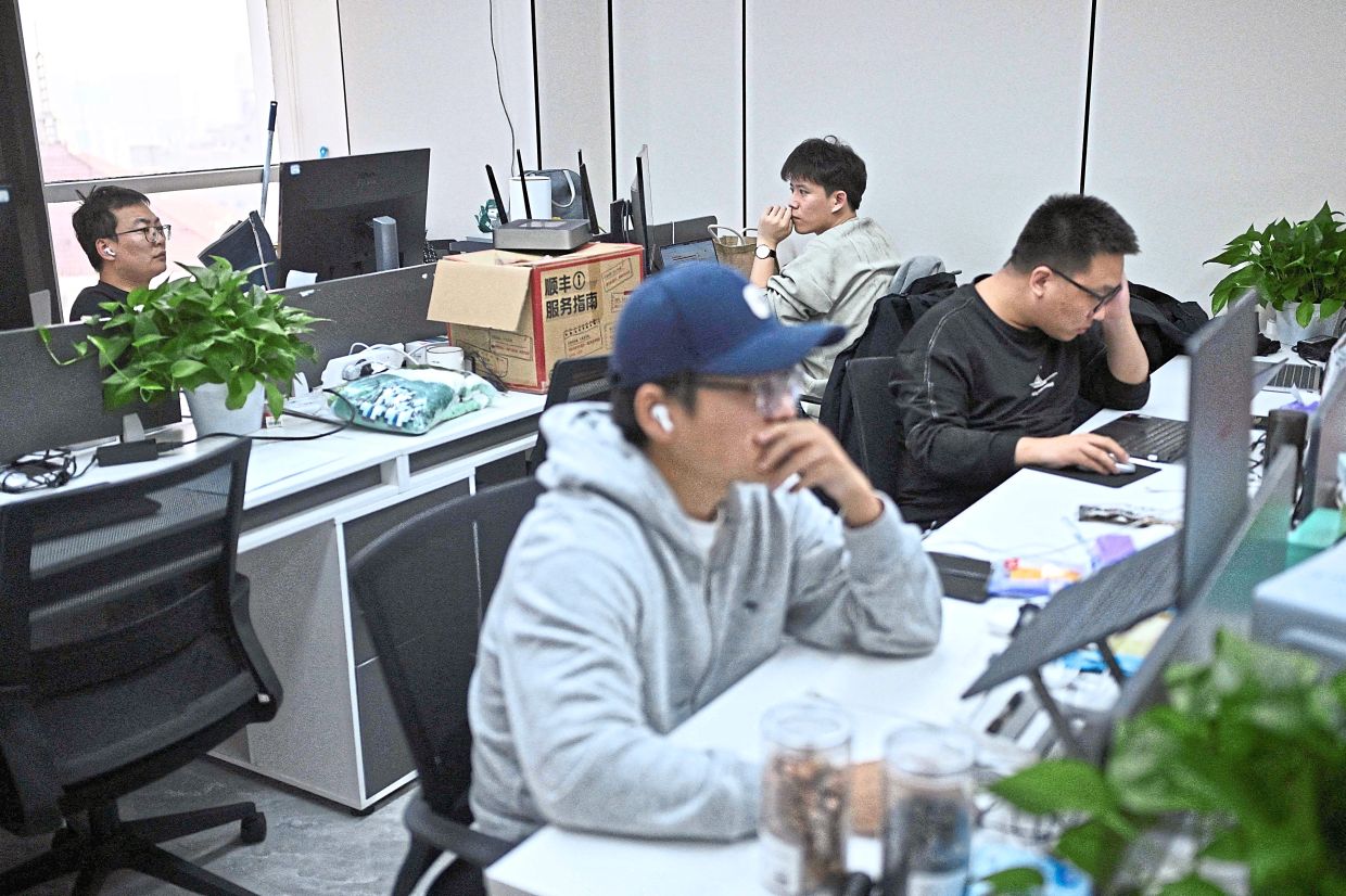 Creators and their creations: Employees at the AIpai video generation platform working at their office in Beijing.