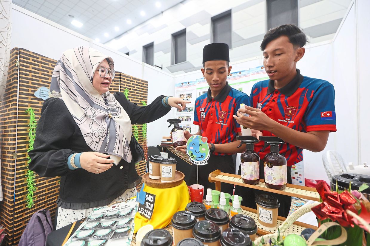 Sulasteri (left) and her students showcasing some of the innovative products from SM Pendidikan Khas Vokasional Indahpura.