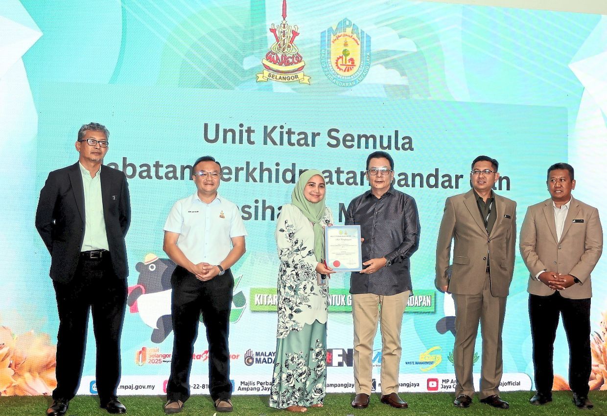 (From second right) Hasrolnizam and Kamri during one of the prizepresentations at mPaJ’s environmental Health day event. Looking on isyew (second from left).