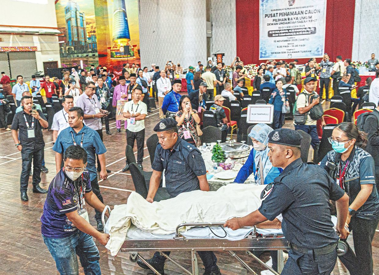 In shock: Dusi on a stretcher after fainting while waiting for nominations to be finalised at the Tuaran nomination centre. — ZULAZHAR SHEBLEE/The Star