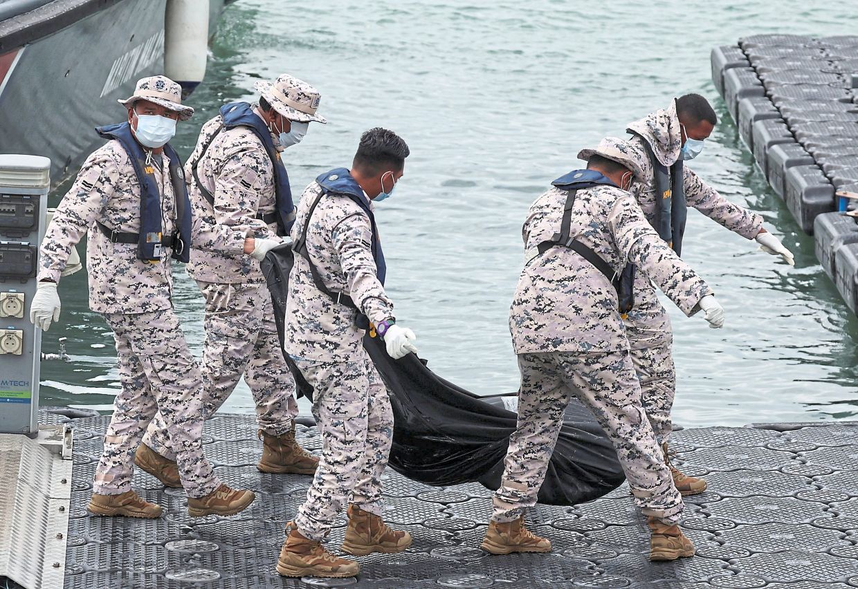 Malaysia Coast Guard officers carrying the body of a deceased victim from the boat that sank near Langkawi. — Reuters