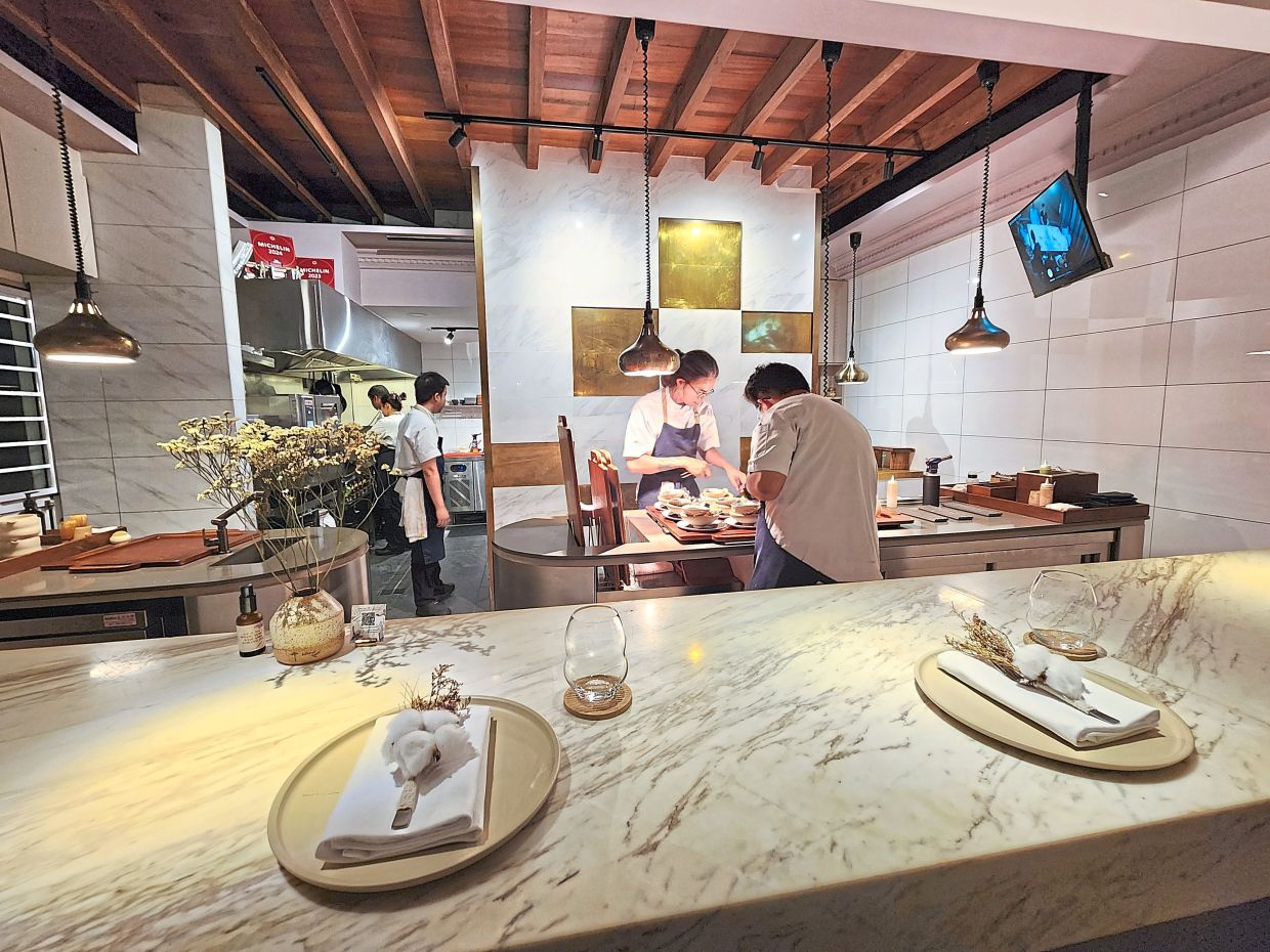 The large open kitchen highlights the work that it takes to produce a Michelin-starred meal. — Photo: ABIRAMI DURAI/The Star