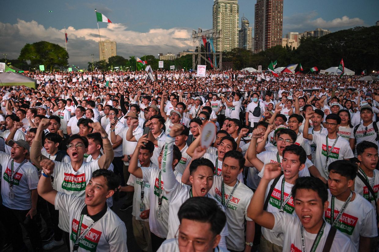 Members of the religious sect Iglesia ni Cristo raise clenched fists as they shout slogans during an anti-corruption protest at a park in Manila on Monday, November 17, 2025. -- Photo by Ted ALJIBE / AFP