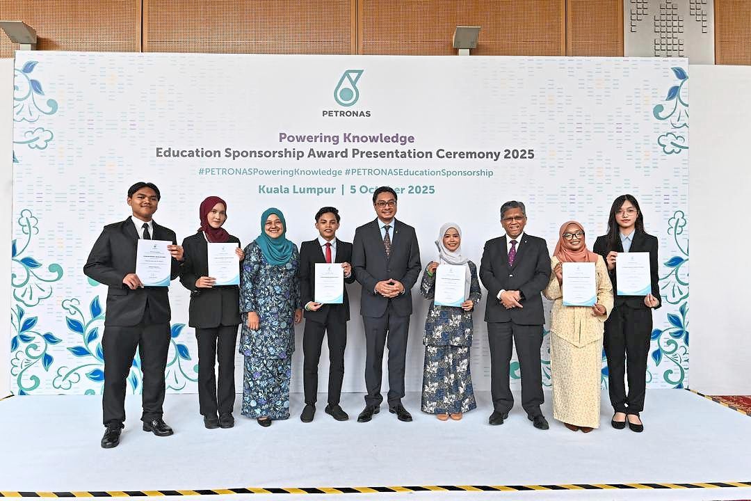PETRONAS human capital expertise senior general manager Akmal Niza Ahmad (third from left), together with Ruslan (centre) and Malaysia Petroleum Management senior vice-president Datuk Bacho Pilong (third from right), posing with some of the recipients of the PETRONAS Powering Knowledge Education Sponsorship during the 2025 award presentation ceremony held at the Kuala Lumpur Convention Centre.