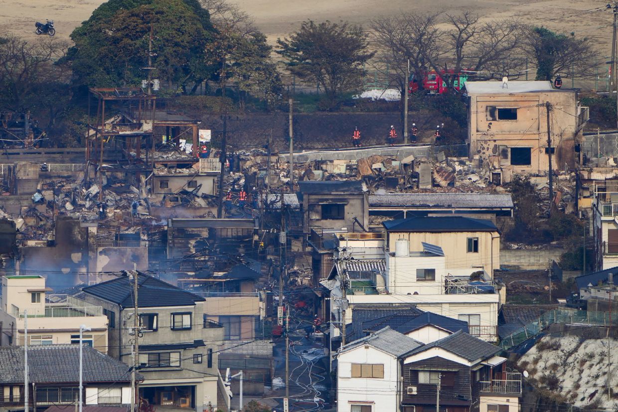Smouldering buildings are seen following an overnight fire at a residential area near the Saganoseki Fishing Port in Oita City on Nov 19, 2025. One person was unaccounted for while 175 others were evacuated as a major fire engulfed a residential area in Japan, the local government said Nov 19. - AFP