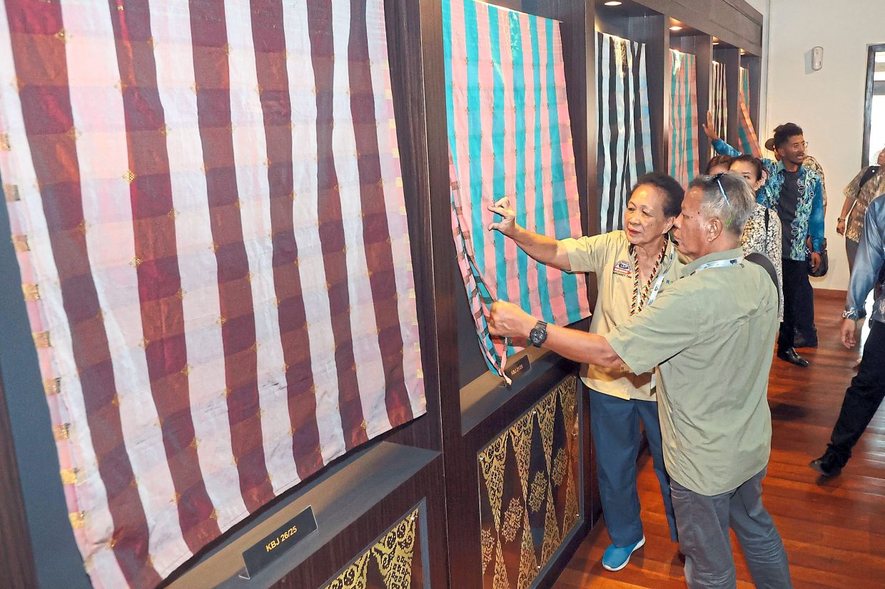 参与者在参观苏丹阿布巴卡遗产中心期间听取有关传统织物的简介。