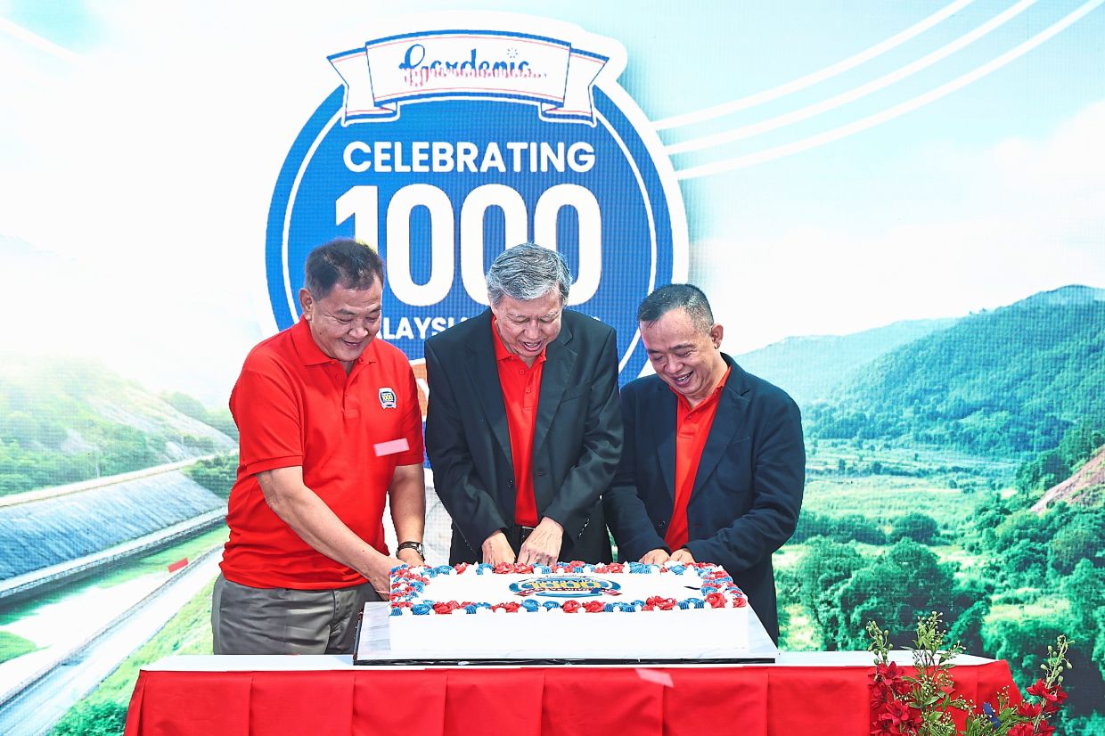 (From left) Abdul Hamid, Koh and Khoo cutting a cake to commemorate the company’s 1,000 routes.