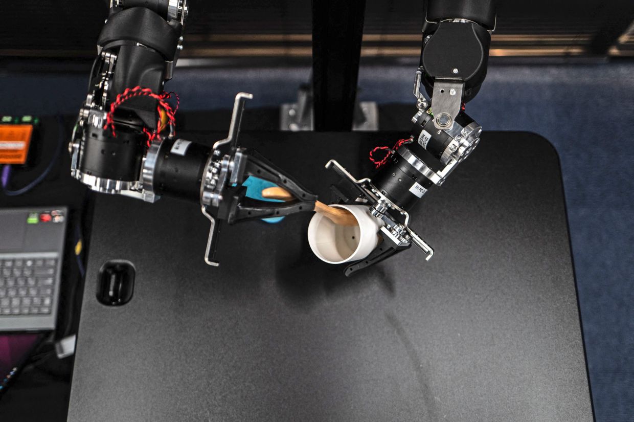 A pair of swivelling,human-like robotic arms mirror the motions of the operator. — AFP