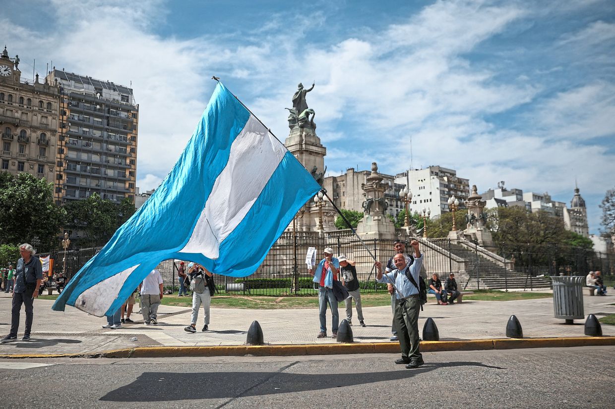 A man waving an Argentine flag during one of the weekly protests demanding higher pensions for retirees outside the National Congress in Buenos Aires. — Reuters