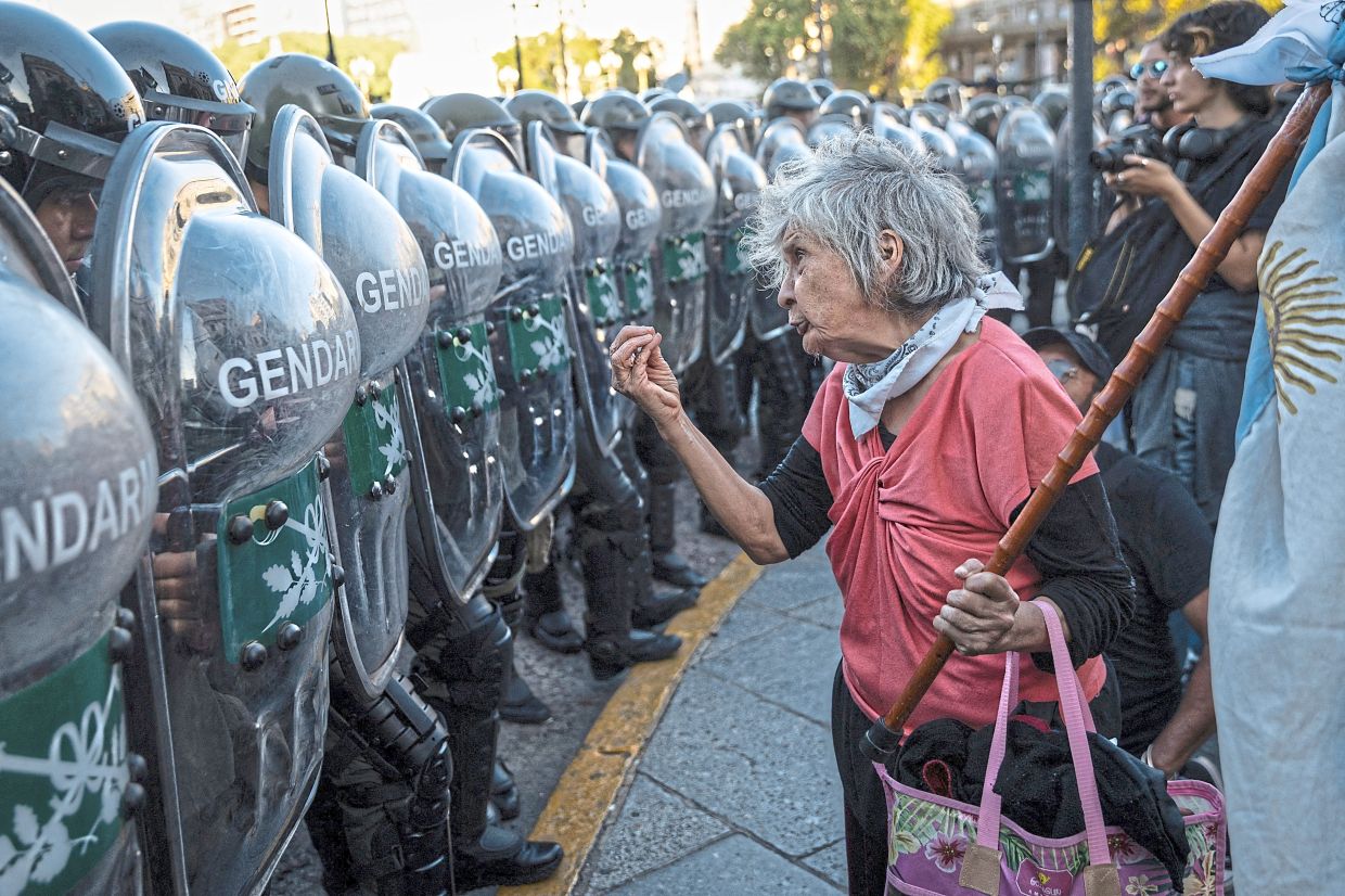 A woman gestures in front of police officers during a demonstration against the adjustment policies put in place by Argentina’s President Javier Milei, in Buenos Aires. — Reuters