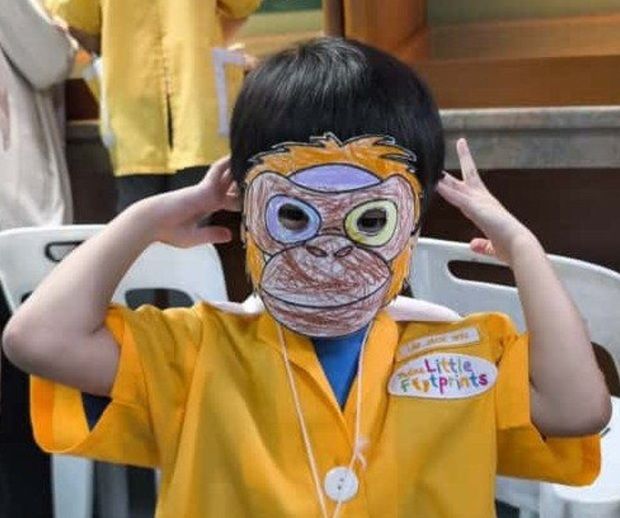 A child showing the animal mask done in a craft workshop.