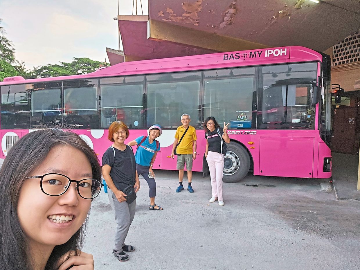 笔者（身穿黄色衬衫）一行人与粉色巴士合影。 — 齐凯
