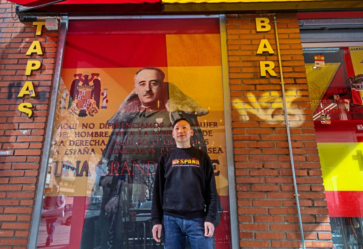 Chinese bar owner Chen Xianwei posing in front of his bar named ‘Una, grande y libre’ (One, great and free) – Franco’s motto for Spain – in Madrid. — AFP