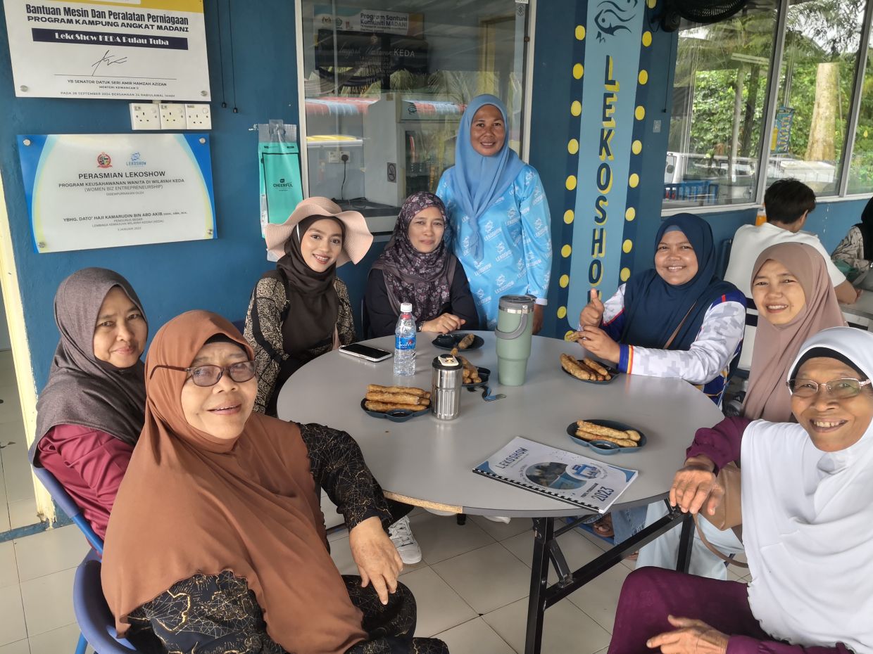 Lekoshow has helped to put Pulau Tuba on the tourist map in Langkawi, as many tourists like the ones pictured here travel just to try Rosnani's (standing) keropok lekor. — ALAN TEH LEAM SENG