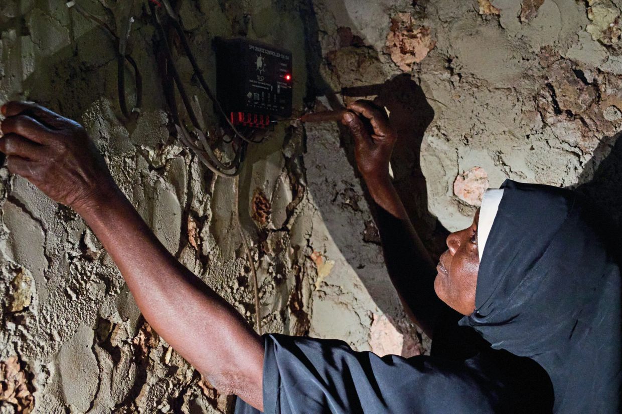 Hamad wires up a solar charge controller at the campus of the college as part of her training. Photo: AP