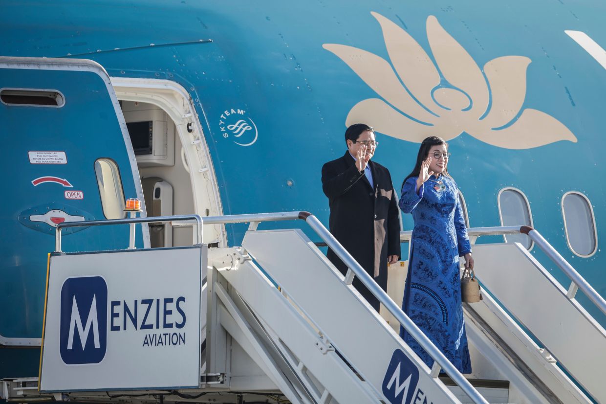 Vietnam's Prime Minister Pham Minh Chinh (left) and his wife Le Thi Bich Tran wave during their arrival at the OR Tambo International airport in Ekurhuleni on Friday, Nov 21, 2025, ahead of the G20 leaders' Summit. --Photo: Marco Longari /Pool Photo via AP