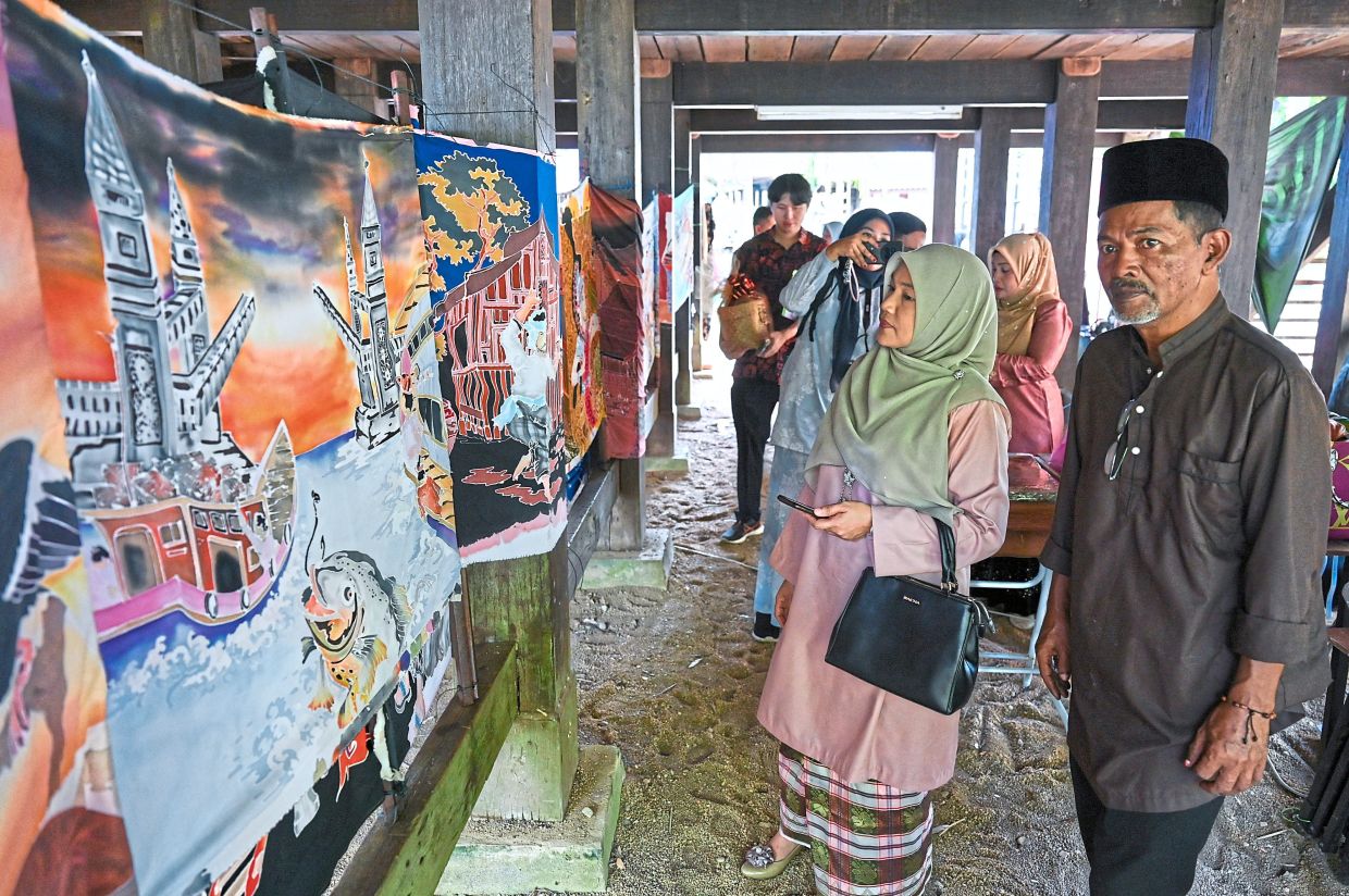 Zubariah (second from right) visiting a booth featuring painted batik at the festival highlighting Terengganu’s traditional arts, foods and culture. —Bernama
