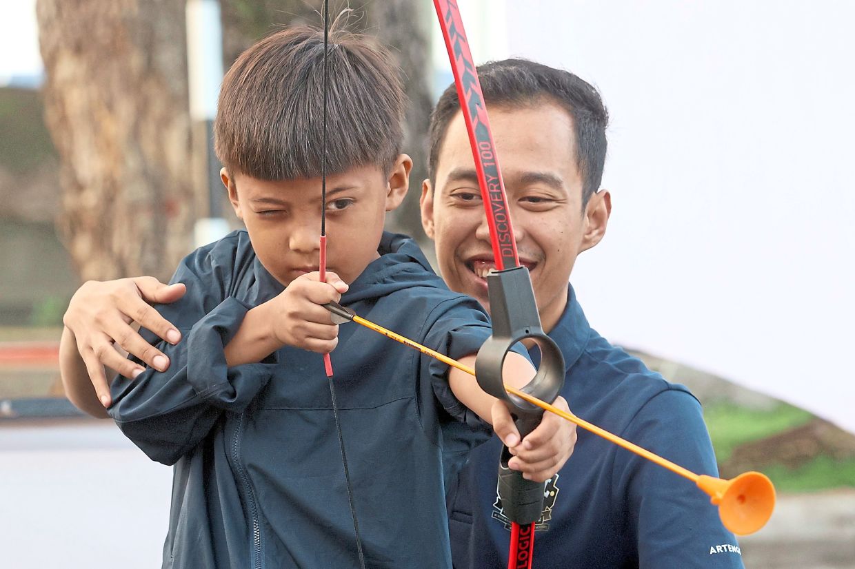 A boy tries archery at Johor Car-Free Morning.