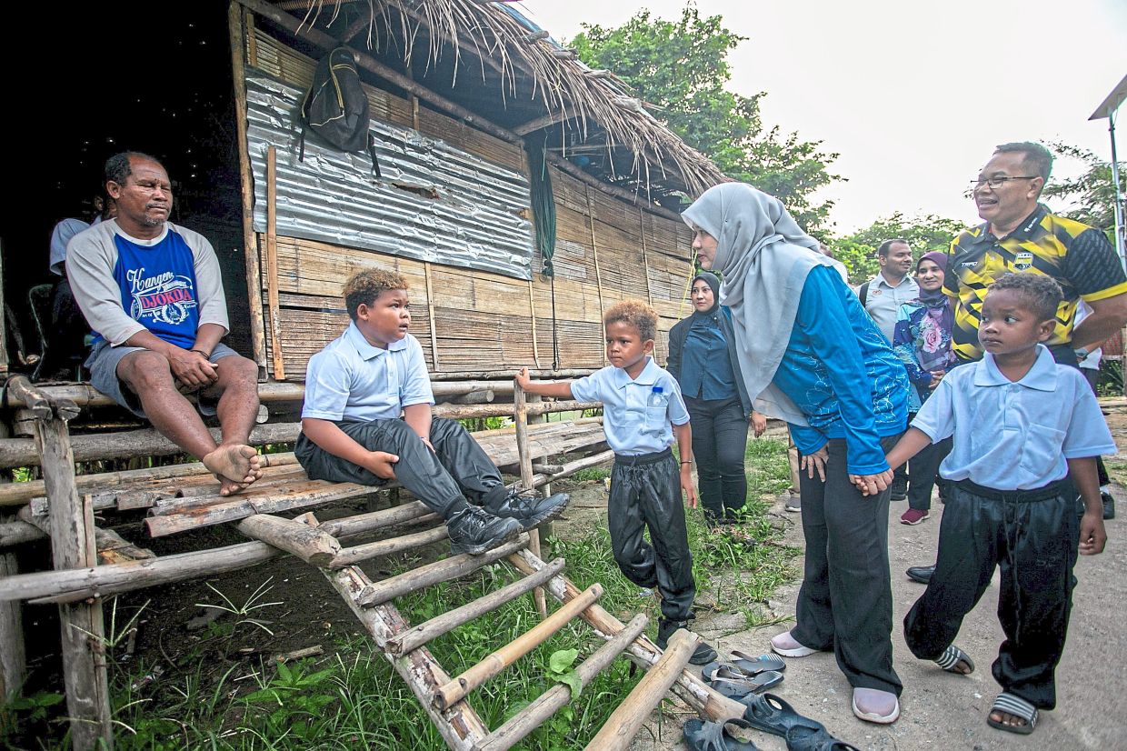 Fadhlina chatting with a pupil while visiting Kampung Charuk Bus. — Bernama