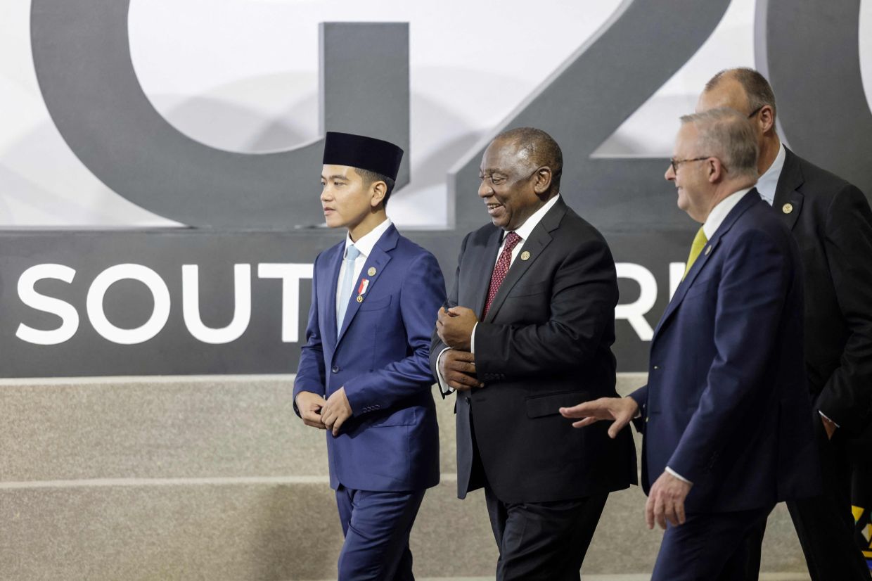 Indonesia's Vice President Gibran Rakabuming Raka (left), South Africa's President Cyril Ramaphosa (2nd L) and Australia's Prime Minister Anthony Albanese react ahead of the family picture at the G20 Leaders' Summit at the Nasrec Expo Centre in Johannesburg on Saturday, November 22, 2025. -- Photo by GIANLUIGI GUERCIA / AFP
