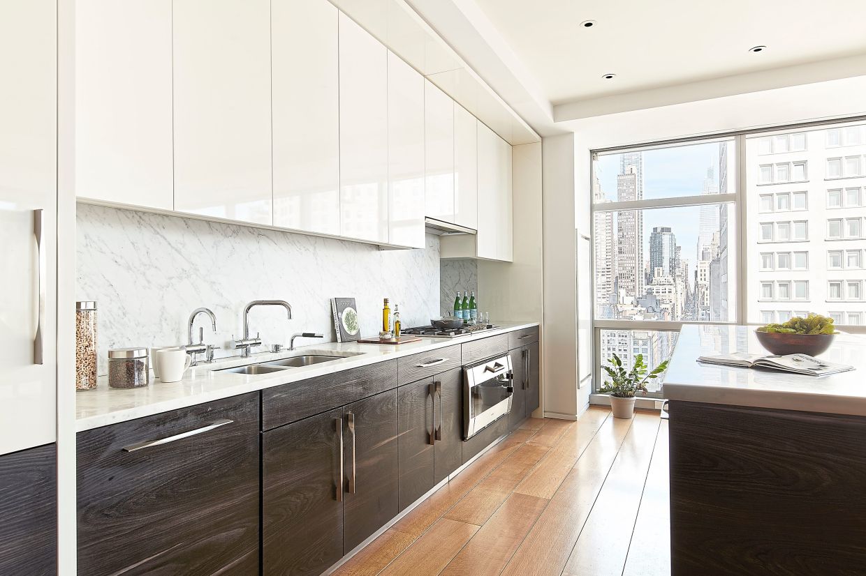 High-gloss cabinetry is paired with dark cabinetry in this open kitchen.