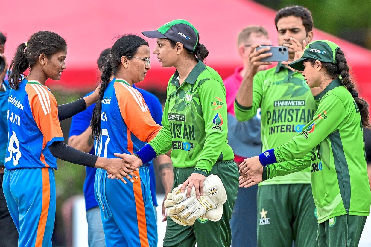 Pakistan's players (right) shake hands with India's players.