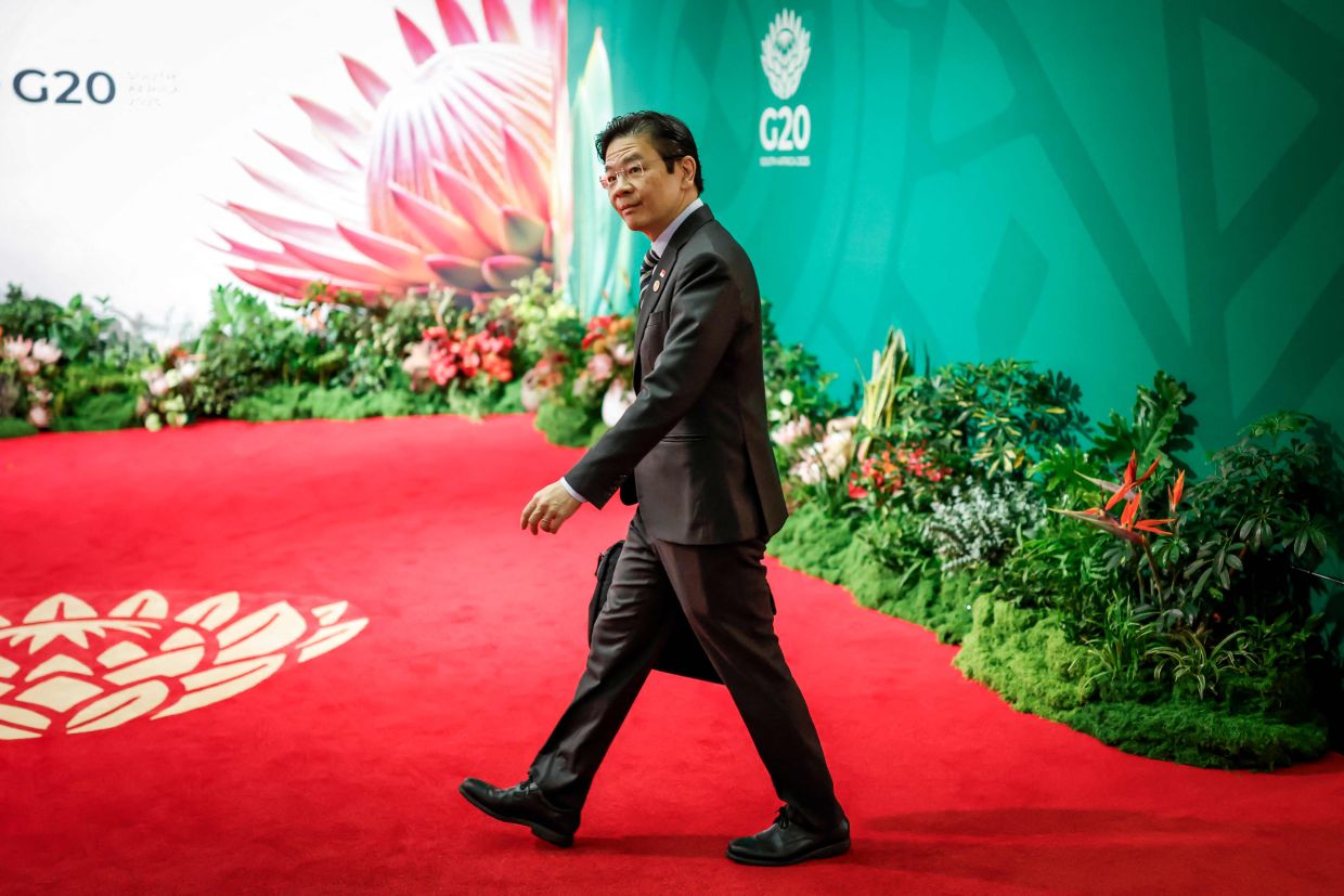 Singapore's Prime Minister Lawrence Wong arrives for the second day of the G20 Leaders' Summit at the Nasrec Expo Centre in Johannesburg on Sunday, November 23, 2025. -- Photo by Marco Longari / POOL / AFP