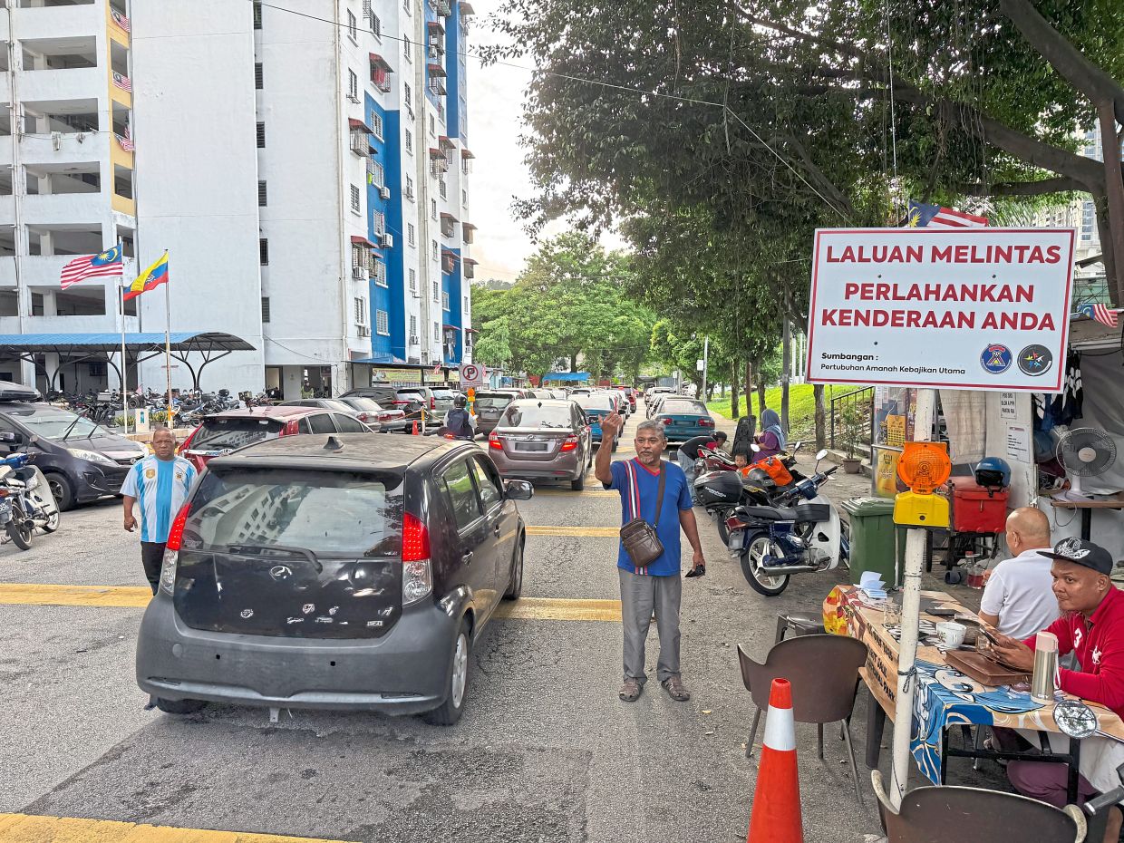 At PPR Pantai Ria, residents have set up volunteer groups to direct traffic at roads that have been narrowed by double parking.